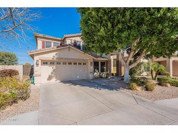 Charming two-story home featuring a spacious two-car garage and beautifully landscaped front yard with mature trees at 2418 E Glass Ln, Phoenix, AZ 85042