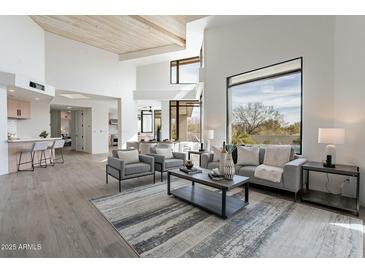 Bright living room featuring high ceilings, modern furnishings, and large windows with natural light at 39493 N 107Th Way, Scottsdale, AZ 85262