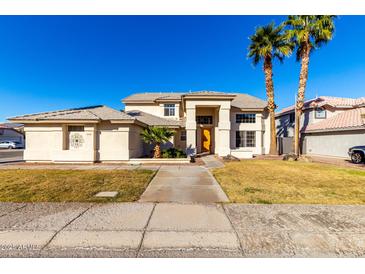 Two-story house with landscaped yard and palm trees at 5748 W Soft Wind Dr, Glendale, AZ 85310