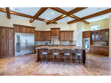 Gourmet kitchen with island, stainless steel appliances, and wood beams at 7575 E Camino Salida Del Sol --, Scottsdale, AZ 85266