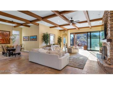 Spacious living room with stone fireplace, high ceilings, and access to backyard at 7575 E Camino Salida Del Sol --, Scottsdale, AZ 85266