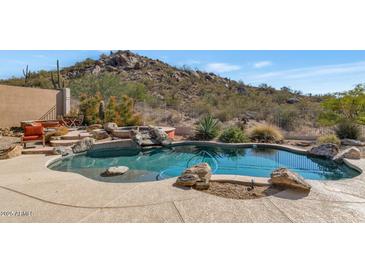 Inviting freeform pool with a natural rock border and desert landscaping at 7575 E Camino Salida Del Sol --, Scottsdale, AZ 85266