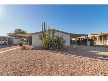 Single-wide manufactured home with covered carport and desert landscaping at 1126 S 97Th Way, Mesa, AZ 85208