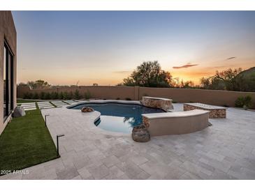 Luxury backyard oasis featuring a large pool, fire pit, and expansive patio at 25838 N 104Th Pl, Scottsdale, AZ 85255