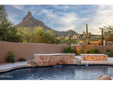 Inviting pool area with desert landscape views and waterfall feature at 25838 N 104Th Pl, Scottsdale, AZ 85255