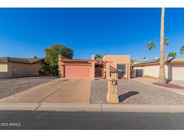 Tan stucco house with a pink garage door and a gravel driveway at 26430 S Pinewood Dr, Sun Lakes, AZ 85248