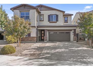 Charming two-story home with a brick paved driveway and neutral colored stucco at 55 N Abalone Ct, Gilbert, AZ 85233