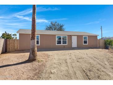 House exterior, tan siding, white door, and mature palm tree at 8155 E Baltimore St, Mesa, AZ 85207