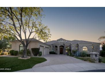 Elegant single-story home with stone accents and a three-car garage at 10360 N 110Th Pl, Scottsdale, AZ 85259