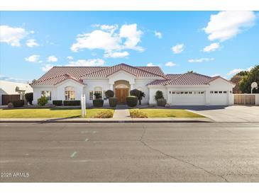 Charming single-story home with lush lawn, mature landscaping, and a three-car garage at 1743 E Menlo St, Mesa, AZ 85203