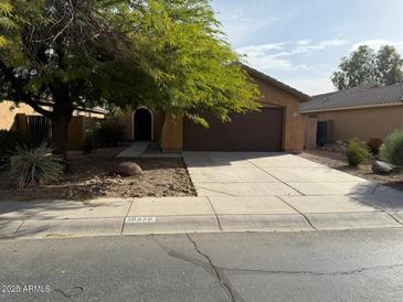 House exterior featuring a two-car garage and landscaped front yard at 19379 N Miller Way, Maricopa, AZ 85139