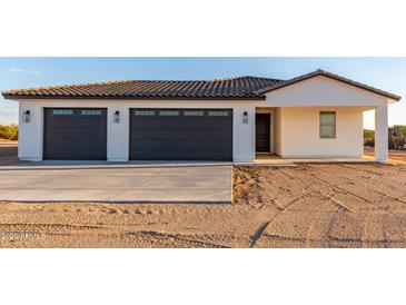 New home exterior boasts a two-car garage and desert landscaping at 23437 E Cactus Forest Rd, Florence, AZ 85132