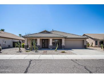 Tan one-story house with a two-car garage and desert landscaping at 3127 W Folgers Rd, Phoenix, AZ 85027