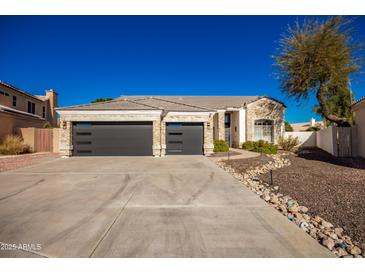 Two-story house with stone accents and a three-car garage at 4430 E Graythorn St, Phoenix, AZ 85044