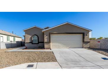 Newly built home with a neutral color scheme and a two-car garage at 603 S 7Th St, Avondale, AZ 85323