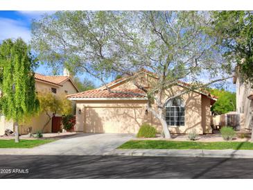 Tan house with tile roof, attached garage, and mature landscaping at 6458 E Raftriver St, Mesa, AZ 85215