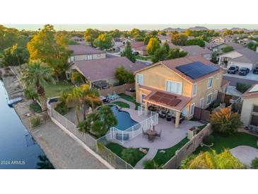 Aerial view of house with pool, spa, and solar panels; located on canal at 6811 W Monona Dr, Glendale, AZ 85308