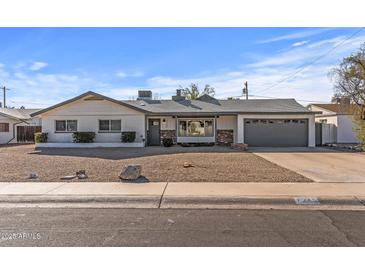 Charming single story home with gray garage door and gravel driveway at 7245 E Cambridge Ave, Scottsdale, AZ 85257