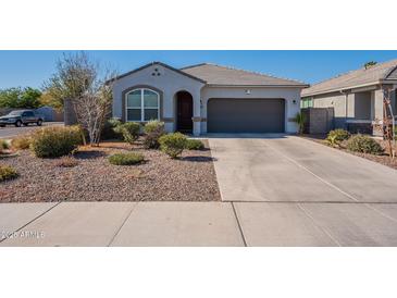 Single-story home with gray exterior, two-car garage, and landscaped front yard at 7950 S 45Th Ave, Laveen, AZ 85339