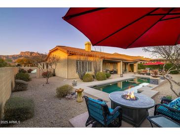 Inviting backyard oasis with a sparkling pool, fire pit, and seating at 8531 E Twisted Leaf Dr, Gold Canyon, AZ 85118