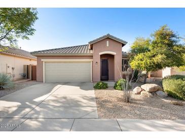 Charming single-story home with a two-car garage, desert landscaping, and a cozy front porch at 2573 W Lewis And Clark Trl, Anthem, AZ 85086