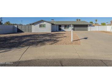 Ranch style home with gray exterior, two-car garage, and a well-manicured front yard at 2914 E Cactus Rd, Phoenix, AZ 85032