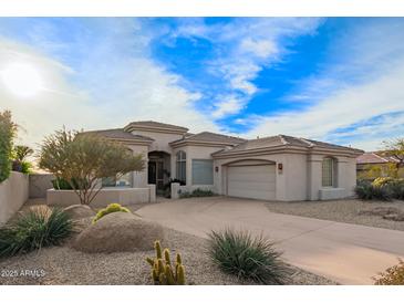 Beautiful desert landscape surrounds this single-story home with a three-car garage at 11003 E Turnberry Rd, Scottsdale, AZ 85255