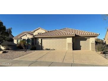 Single-story home with three-car garage and desert landscaping at 15856 W Sage Trl, Surprise, AZ 85374