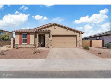 Charming single-story home with a tile roof, stone accents, and a two-car garage at 18188 W Fulton St, Goodyear, AZ 85338