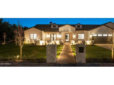 Stunning curb appeal! This home features a brick facade, landscaped lawn, and a paved pathway at 5539 E Camelback Rd, Phoenix, AZ 85018