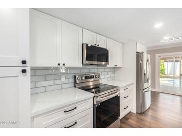 Modern kitchen with stainless steel appliances and white cabinets at 9412 N 33Rd Way, Phoenix, AZ 85028