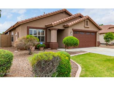 One-story house with brown exterior, landscaped yard, and two-car garage at 10245 W Jessie Ln, Peoria, AZ 85383