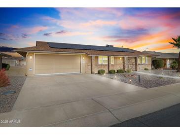 House exterior with solar panels and landscaped yard at 10537 W Prairie Hills Cir, Sun City, AZ 85351