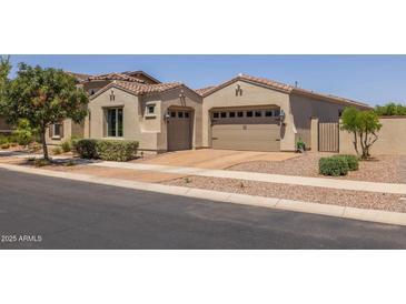 Spacious three-car garage with a tile roof and desert landscaping at 10550 E Sanger Ave, Mesa, AZ 85212