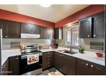 Bright kitchen features dark cabinetry, stainless steel appliances, and white countertops at 131 N Higley Rd # 213, Mesa, AZ 85205