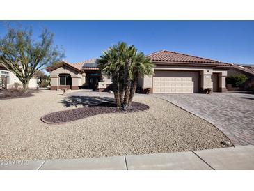 Single-story home with desert landscaping, large driveway, and three-car garage at 20825 N Limousine Dr, Sun City West, AZ 85375