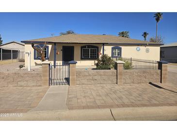 Cute single story home with a well-manicured front yard and gated entrance at 302 E Beech Ave, Casa Grande, AZ 85122