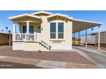 Bright yellow single-wide manufactured home with covered carport and small front porch at 305 S Val Vista Dr # 71, Mesa, AZ 85204