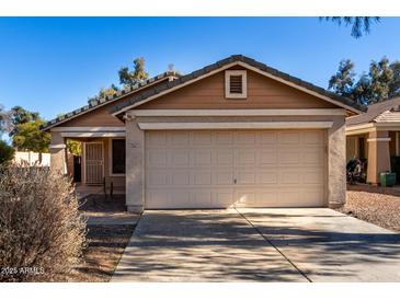 Tan house with a two-car garage and desert landscaping at 34717 N Picket Post Dr, Queen Creek, AZ 85142