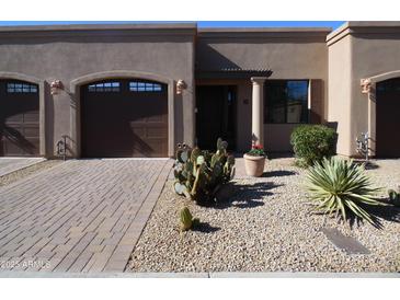 Tan stucco exterior with two-car garage and desert landscaping at 4241 N Pebble Creek Pkwy # 13, Goodyear, AZ 85395