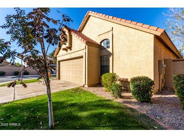 Tan stucco house with a two-car garage and well-manicured lawn at 4698 W Harrison St, Chandler, AZ 85226