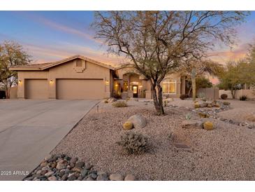 Desert landscape surrounds this one-story home with a three-car garage at 7126 E Bobwhite Way, Scottsdale, AZ 85266