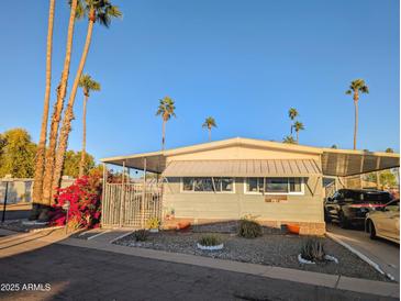 Single-wide manufactured home with carport and landscaped yard at 7300 N 51St Ave, Glendale, AZ 85301