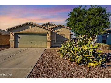 Single-story house with a two-car garage and desert landscaping at 7334 S Morning Dew Ln, Buckeye, AZ 85326