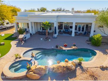 Inviting backyard oasis featuring a large pool, spa, and outdoor entertainment area at 922 E Desert Hills Estate Dr, Phoenix, AZ 85086