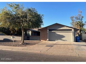 Ranch style home with a two-car garage and mature landscaping at 10138 W Highland Ave, Phoenix, AZ 85037