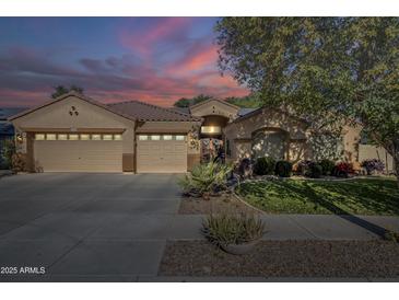 Beautiful home with three-car garage and well-manicured lawn at 16364 W Roosevelt St, Goodyear, AZ 85338