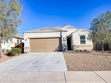 Front view of a single-story house with a brown garage door at 3841 N 293Rd Dr, Buckeye, AZ 85396