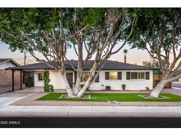 Charming single story home with a manicured lawn and mature trees at 7416 E Holly St, Scottsdale, AZ 85257