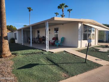 Single-wide manufactured home with covered porch and landscaped yard at 120 N Val Vista Dr # 202, Mesa, AZ 85213